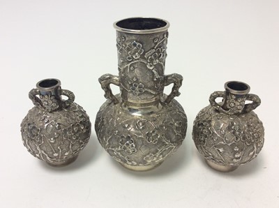 Lot 166 - Pair of late 19th century Chinese silver bottle vases with chased and embossed decoration of prunus, character marks to bases for Wang Hing
