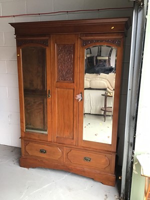 Lot 10 - Art Nouveau mahogany wardrobe, with moulded cornice and twin mirrored doors between relief carved foliate panel and two drawers below on plinth base, 148cm wide x 54cm deep x 201cm high