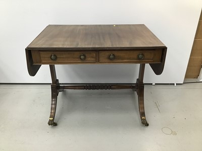 Lot 144 - Regency style mahogany sofa table, hinged crossbanded top with reeded edge and two frieze drawers on standard ends and splayed legs terminating in brass cappings and castors, 91cm wide x 61cm deep...