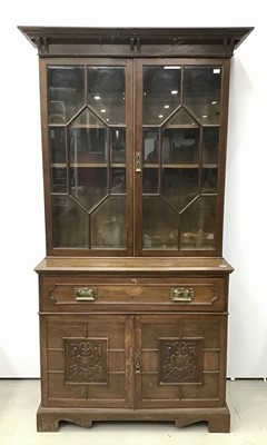 Lot 164 - Edwardian oak two height secretaire bookcase with moulded cornice, adjustable wooden shelves enclosed by two bevelled glazed doors, fitted secretaire drawer and cupboard below enclosed by two carve...