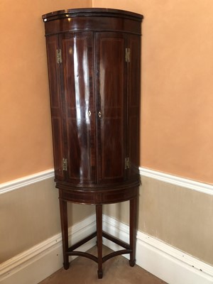 Lot 927 - George III inlaid mahogany barrel front corner cupboard with four shelves, on associated corner stand, 202cm high overall, 70cm wide
