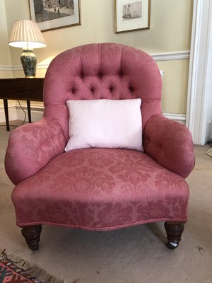 Lot 934 - Victorian buttoned back low easy chair with red upholstery, on turned mahogany legs terminating on brass castors