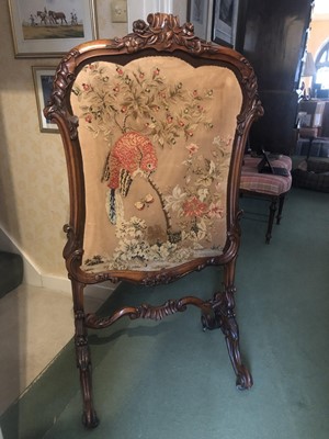 Lot 935 - Fine quality Victorian carved rosewood framed fire screen with carved foliate decoration and embroided panel depicting a particular on fruiting tree, on scroll legs and brass castors, 125cm high x...