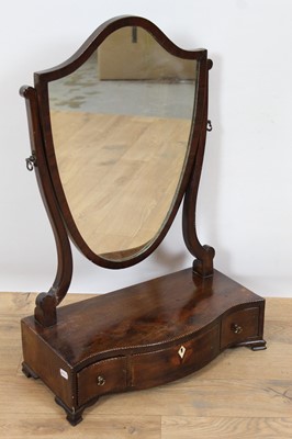 Lot 939 - George III mahogany toilet mirror with shield shaped mirror, with serpentine plateau enclosing three drawers, on ogee bracket feet, 41.5cm wide