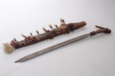 Lot 925 - Late 19th / early 20th century Borneo Dayak Manadu head hunters sword with horn hilt, blade with engraved decoration, in wooden sheath with painted decoration, 62cm overall