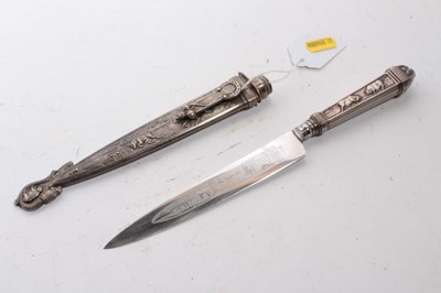 Lot 929 - South American Gaucho Knife / Dagger, etched steel blade by Inox, in silvered scabbard with ornate decoration depicting cattle, 29cm overall