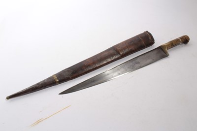 Lot 930 - 19th century Khyber knife, with tapered steel blade, brass mount and ribbed horn grips, in leather covered sheath, blade 40cm in length, 65cm in overall length including scabbard