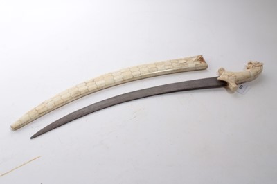 Lot 935 - Unusual Indo Persian Sword with watered steel blade, with carved Lions head pommel, grip and scabbard with bone decoration, 63.5cm overall