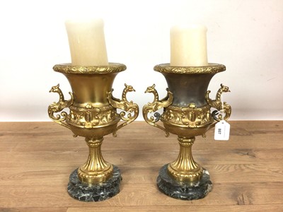 Lot 807 - Pair of gilt metal urns, on marble pedestals