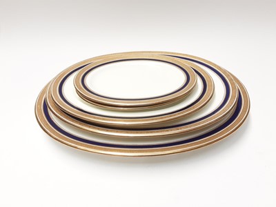 Lot 210 - Cauldon China dinner service with raised gilt border and Colbert blue rim