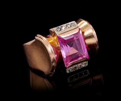 Lot 236 - Art Deco 1940s diamond and pink stone dress ring of 'Odeonesque' design, the rectangular step cut pink stone flanked by rose cut diamonds and exaggerated domed gold disc shoulders on tapered shank....