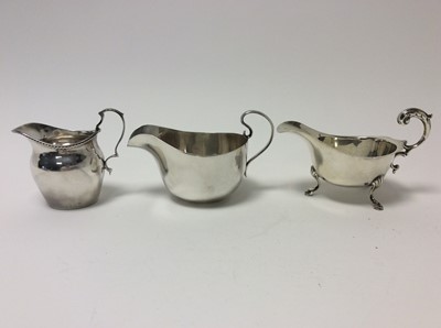 Lot 155 - George VI silver sauce boat of conventional form (Birmingham 1941), together with another silver sauce boat (Sheffield 1922) and a silver cream jug (Birmingham 1912), first sauce boat 14cm in lengt...
