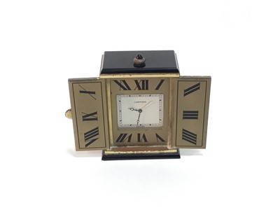 Lot 542 - Art Deco style Cartier miniature travelling timepiece with rectangular dial enclosed by two doors, the interior with black enamel Roman numerals, the exterior with engine turned starburst design, 6...