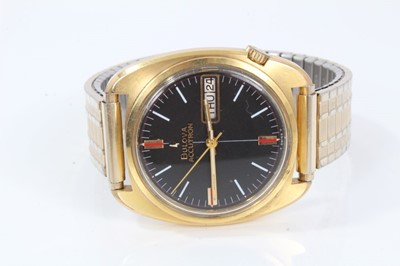 Lot 357 - 1970s gentlemen's Bulova Accutron wristwatch with circular matte black dial, day and date aperture, in tonneau shape gold plated case.