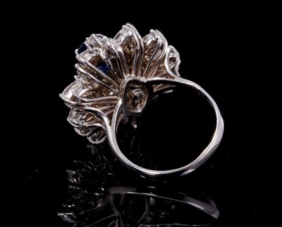 Lot 245 - Sapphire and diamond cluster cocktail ring with an oval mixed cut blue sapphire estimated to weigh approximately 1.75cts surrounded by 18 brilliant cut and 24 marquise cut diamonds in tiered claw s...