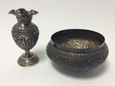 Lot 202 - Late 19th/early 20th century Burmese silver bowl of circular form, with embossed floral and scroll decoration, together with a similar vase, both apparently unmarked, all at 10oz, bowl 11cm in diam...