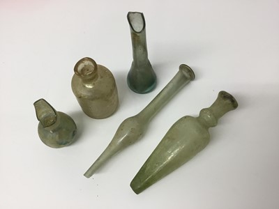 Lot 515 - Two Roman glass perfume bottles, an iridescent vessel and two further vessels, the largest measuring 13.5cm length (5)
