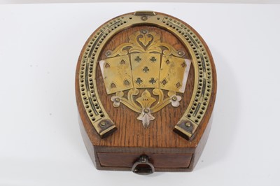 Lot 502 - A late Victorian oak and brass mounted cribbage board in the form of a horseshoe, the top with an applied panel of three cards, bearing stamped mark 'D & A', the front fitted with a drawer with an...