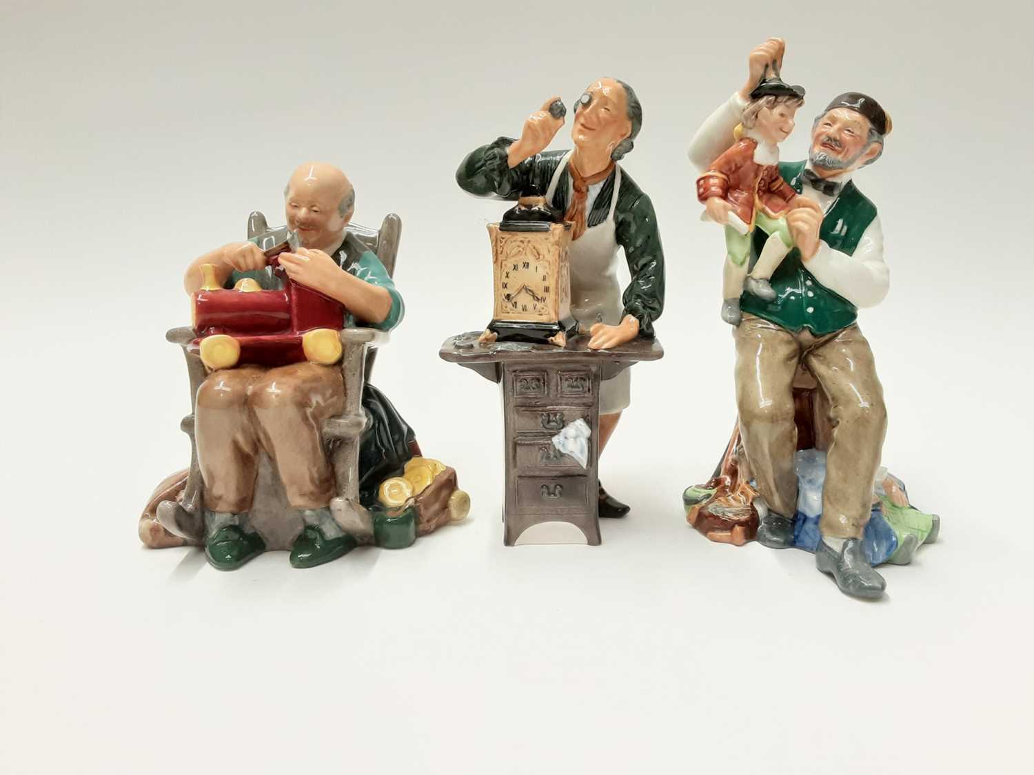 Lot 45 - Three Royal Doulton figures - The Toymaker HN2250, The Puppetmaker HN2253 and The Clockmaker HN2278