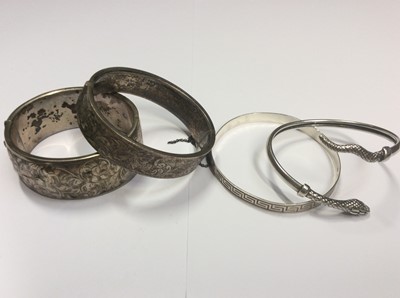 Lot 505 - Two engraved hinged silver bangles, silver snake torque bangle and silver Greek key design bangle (4)