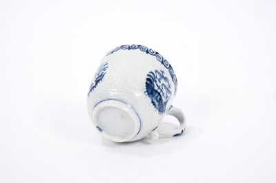 Lot 21 - Lowestoft coffee cup, with a scrolled handle, moulded in relief in Hughes style with flowers, diaper panels and three circular panels painted in blue with different Chinese scenes, scrolled border...