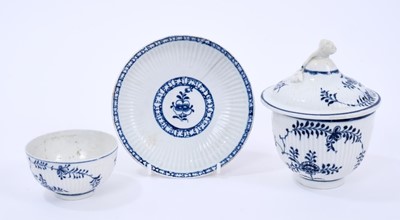 Lot 41 - Three Lowestoft pieces, all ribbed, including a sucrier and cover, with flower finial, painted in blue the 'Immortelle' pattern, crossed swords mark, 23cm high, a tea bowl painted in the same patte...