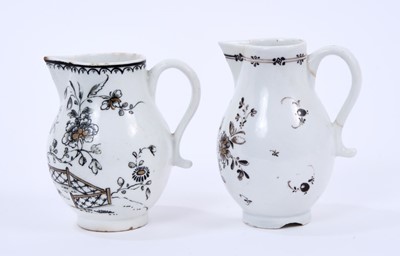 Lot 50 - Two Lowestoft sparrow beak jugs, the first strongly pencilled in black with a Question Mark rock beside a fence and flowering plants, highlighted in gold, loop and line border below rim