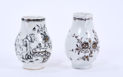 Lot 50 - Two Lowestoft sparrow beak jugs, the first strongly pencilled in black with a Question Mark rock beside a fence and flowering plants, highlighted in gold, loop and line border below rim