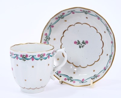 Lot 60 - Lowestoft coffee cup and saucer, of faceted form with a scrolled handle, the centre in pink and green with with a flower sprig within a gilded band, a 'Bungay' border enclosing a band of gilt stars...