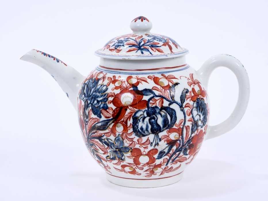 Lot 62 - Lowestoft teapot and cover, of globular form with a straight spout and mushroom finial, printed in blue with large scale flower specimens including lilies and carnations, over painted around with f...