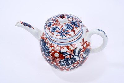 Lot 62 - Lowestoft teapot and cover, of globular form with a straight spout and mushroom finial, printed in blue with large scale flower specimens including lilies and carnations, over painted around with f...