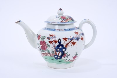 Lot 63 - Large Lowestoft teapot and cover, of globular form with a curved spout and mushroom finial, painted in colours with rockwork and plants within a fenced enclosure, the underglaze blue border with ir...