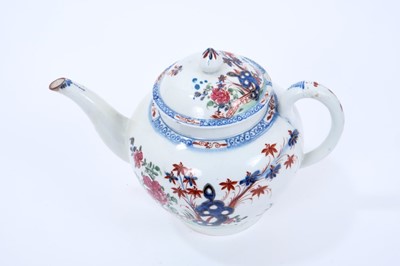 Lot 63 - Large Lowestoft teapot and cover, of globular form with a curved spout and mushroom finial, painted in colours with rockwork and plants within a fenced enclosure, the underglaze blue border with ir...
