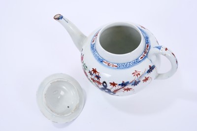 Lot 63 - Large Lowestoft teapot and cover, of globular form with a curved spout and mushroom finial, painted in colours with rockwork and plants within a fenced enclosure, the underglaze blue border with ir...