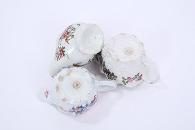 Lot 66 - Three Lowestoft cream jugs, the first of Low Chelsea ewer form, painted in 'Tulip Painter' style, 10.2cm wide, the second of the same form a painted in underglaze blue and red with floral sprays pi...