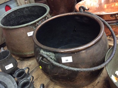 Lot 86 - Two antique copper cauldrons with swing handles together with a brass cauldron (3)