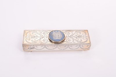 Lot 417 - Edwardian silver match box holder of rectangular form with engraved decoration and central Jasperware panel inset to the top, raised on four ball feet, (London 1905), maker E D, 16cm in length