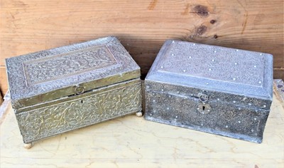 Lot 46 - 19th century Indian tooled brass casket relief decorated with scrolling foliage, on bun feet, 33cm wide, together with a similar white metal covered casket (2)