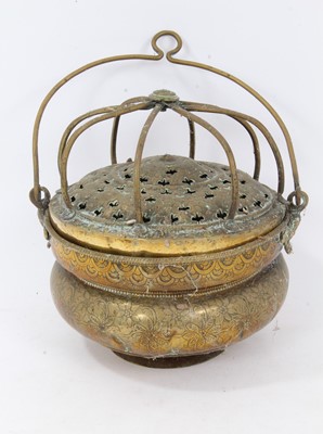 Lot 879 - 17th century brass censer, with pierced domed cover and surmounting cage, the squat vessel with foliate ornament and swing handle, 18cm diameter 
Provenance: Estate of the Late Jane Sumner
