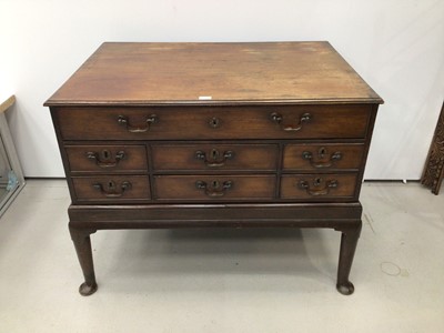 Lot 36 - Georgian mahogany chest on stand with an arrangement of drawers, the top long drawer enclosing pigeon holes and small drawers above six short drawers with brass swan neck handles, on associated sta...