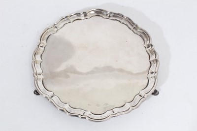 Lot 333 - Georgian Silver salver of circular form with piecrust borders, raised on three hoof feet, marked rubbed all at approximately 17oz, 23cm in diameter