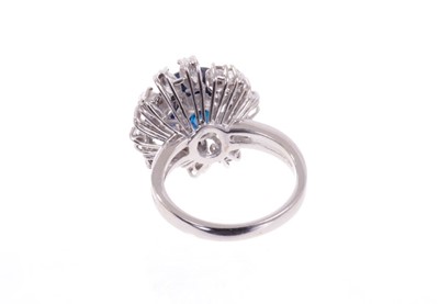 Lot 488 - Sapphire and diamond cluster cocktail ring with an oval mixed blue sapphire measuring approximately 11.75mm x 8.75mm x 5.75mm, surrounded by an asymmetric border of brilliant cut and marquise cut d...