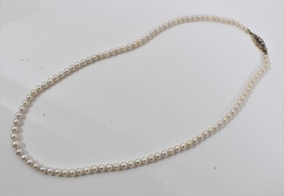Lot 516 - Cultured pearl necklace with a string of graduated cultured pearls measuring approximately 5.5mm to 3.5mm on a good quality 14ct (585) gold and diamond clasp. Length approximately 45cm. In an assoc...