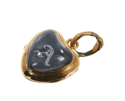 Lot 525 - Victorian gold and red enamel heart shaped locket enclosed by glazed front with intaglio engraved gothic 'A', the reverse with red guilloche enamel and suspended from a snake loop. 25mm x 15mm.