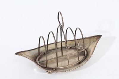 Lot 423 - Edwardian silver wire frame four division toast rack on tray of navette form with egg and dart borders, raised on bun feet, (Chester 1908), maker George Nathan & Ridley Hayes, all at 7oz, 21cm in l...