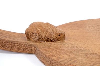 Lot 879 - Peter 'Rabbitman' Heap of Wetwang, oak cheese board of oval form with carved Rabbit signature to the base of the handle.  
N.B. Peter Heap was a former ‘Mouseman’ apprentice, before leaving to set...