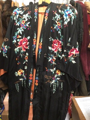 Lot 2100 - Chinese black silk robe with polychrome silk embroidered flowers, reversible orange silk with flowers.