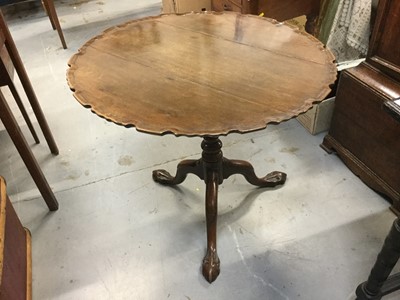 Lot 909 - Georgian mahogany wine table with tilting circular top with pie crust border, turned central column on three claw and ball feet, 69 x 76cm