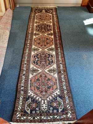 Lot 1067 - Eastern rug with geometric decoration on blue and cream ground, 295cm x 76cm