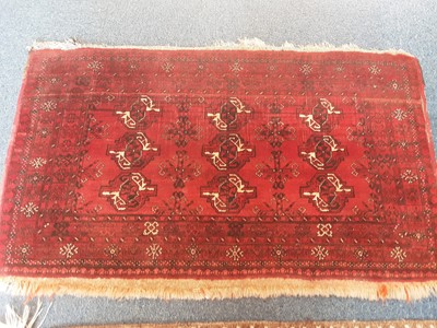 Lot 1072 - Eastern rug with geometric decoration on red ground, 133cm x 77 and another rug, 148cm x 75cm